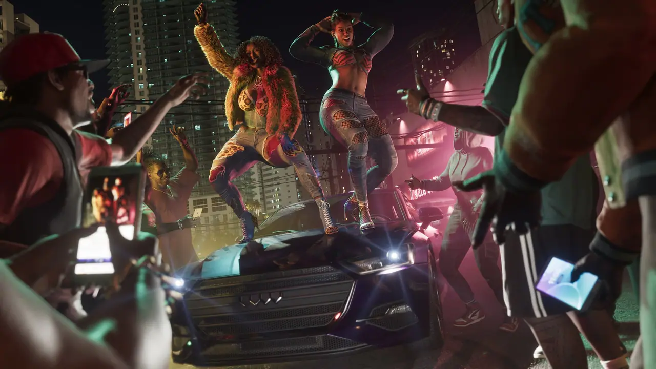 Real Dimez performing on the roof of a car at a night street party while the crowd films on their phones